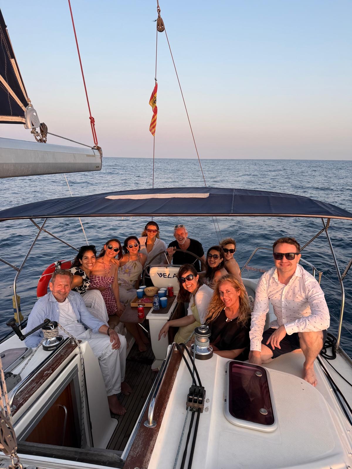 Juliana with a group of travelers enjoying an evening aboard a sailboat