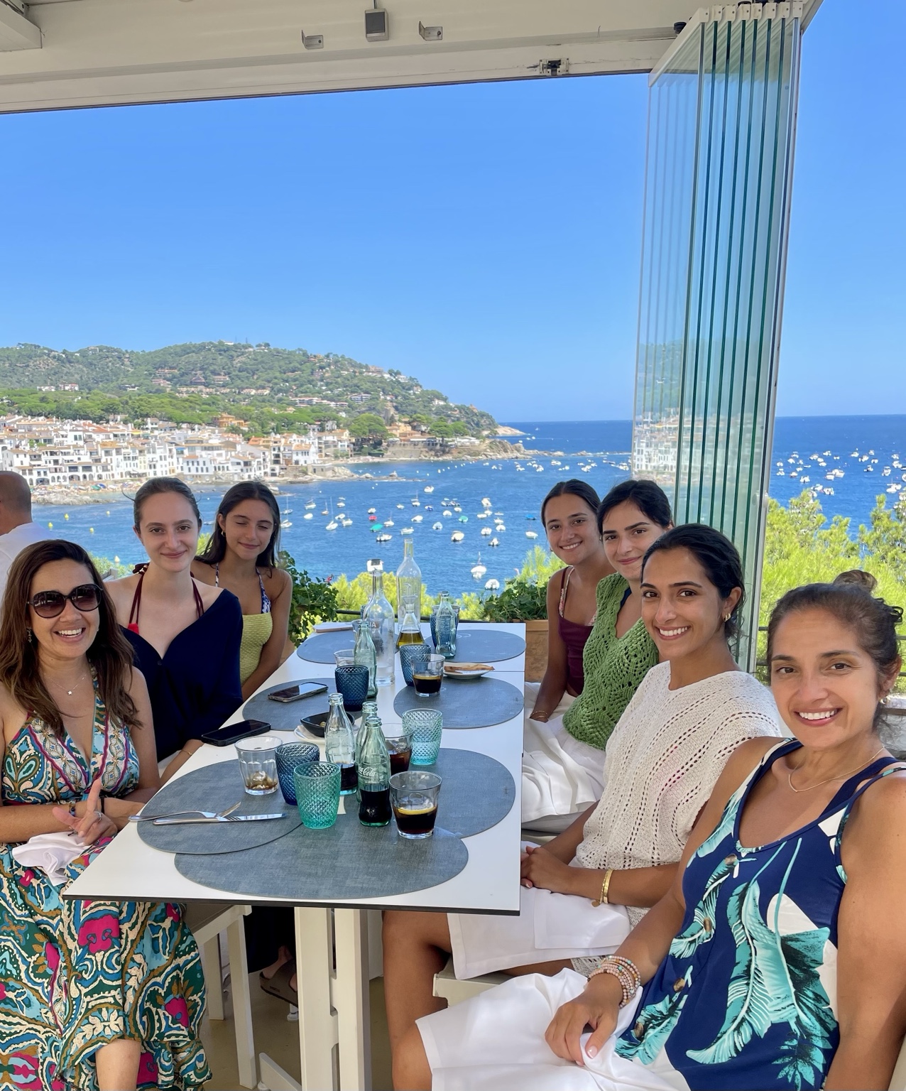 Juliana and travelers sharing a meal overlooking the Costa Brava