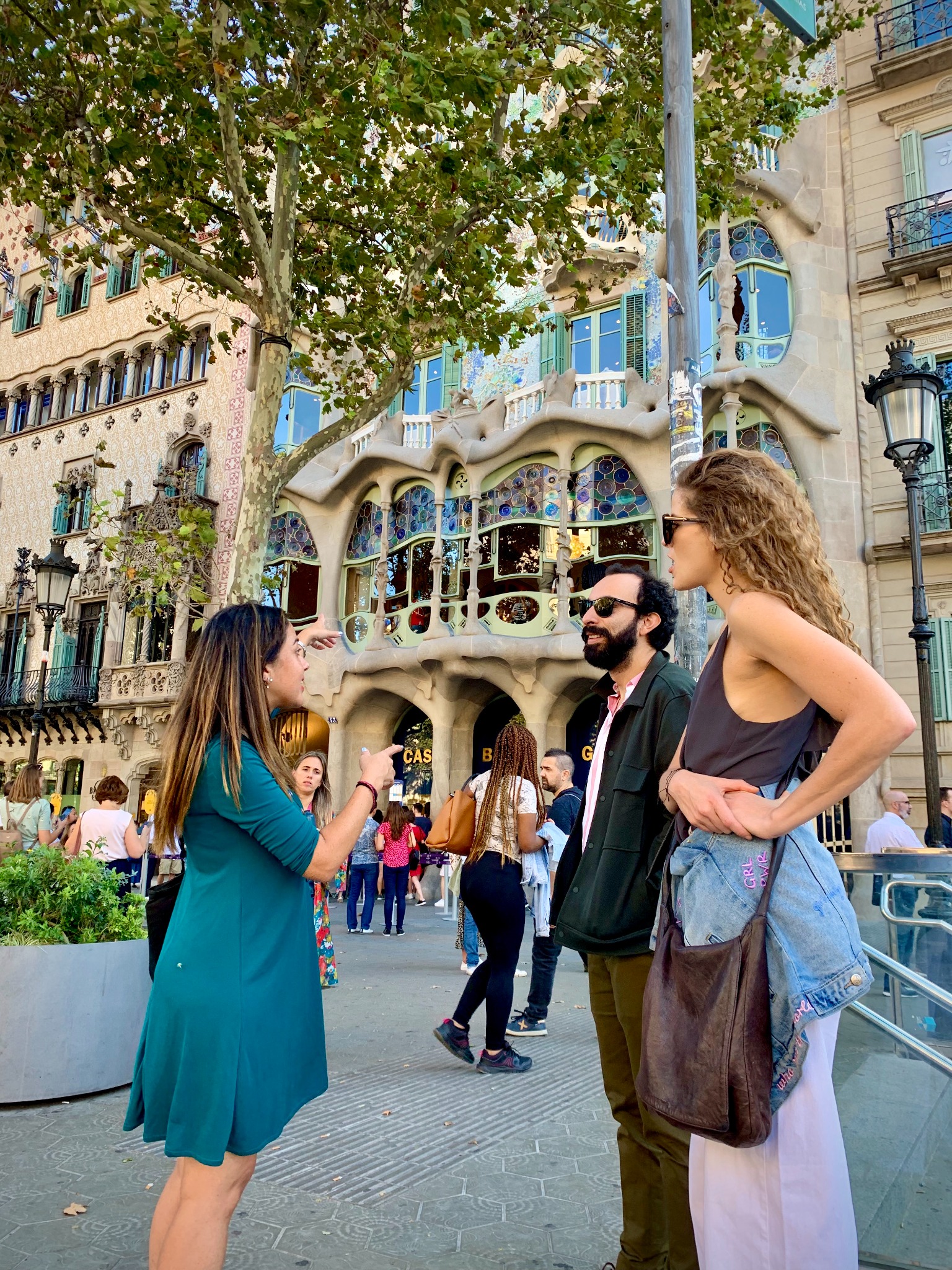 Juliana sharing Gaudí’s architecture with two travelers outside Casa Batlló