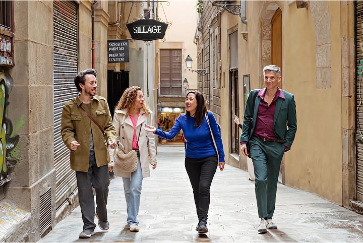 Juliana and three travelers walking and conversing in the Gothic Quarter